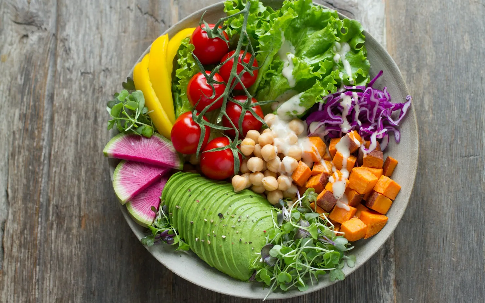 A colorful grain bowl with vegetables and greens